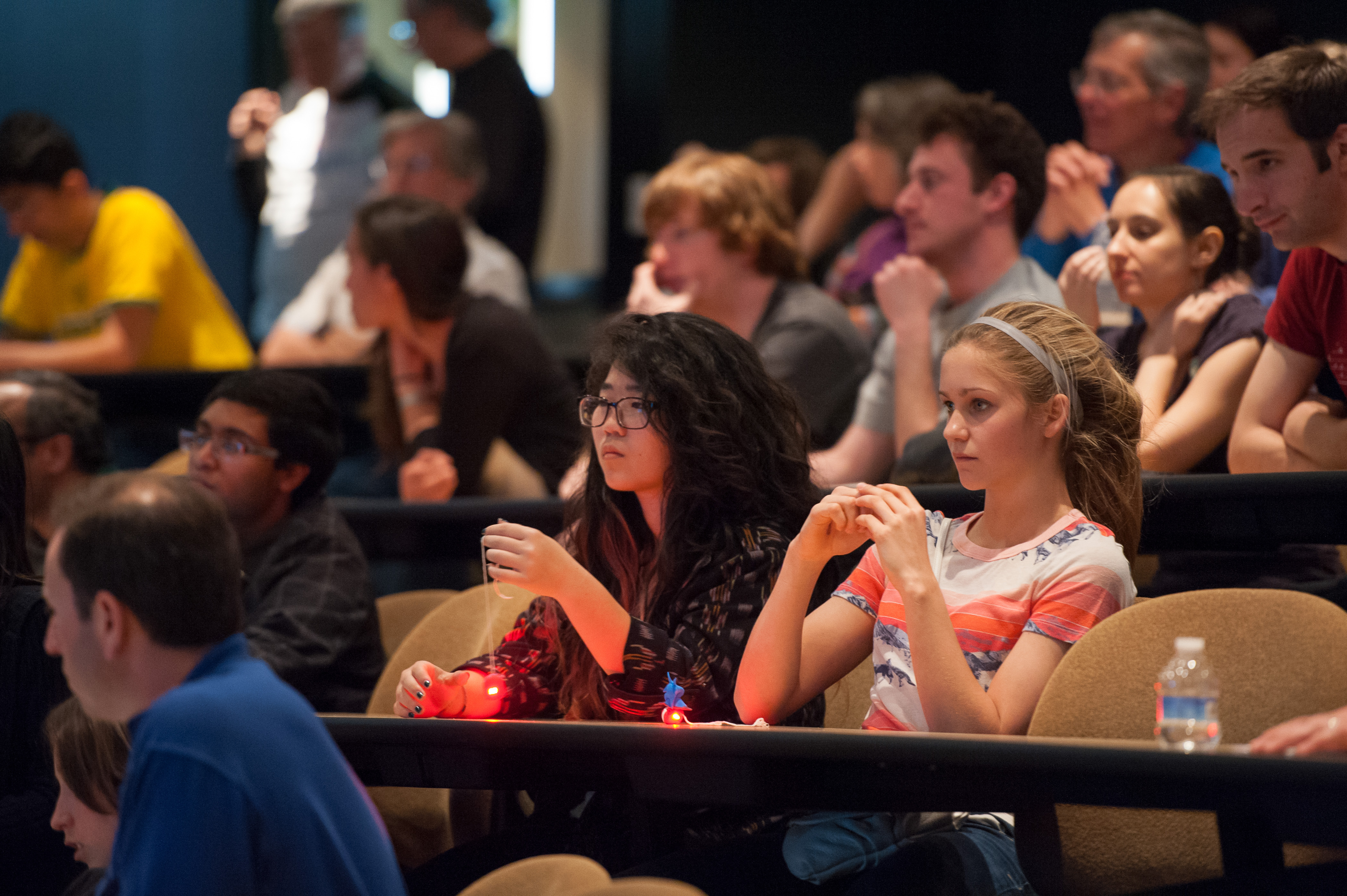 Photo of audience members holding handmade pulsars learn about astrophysics