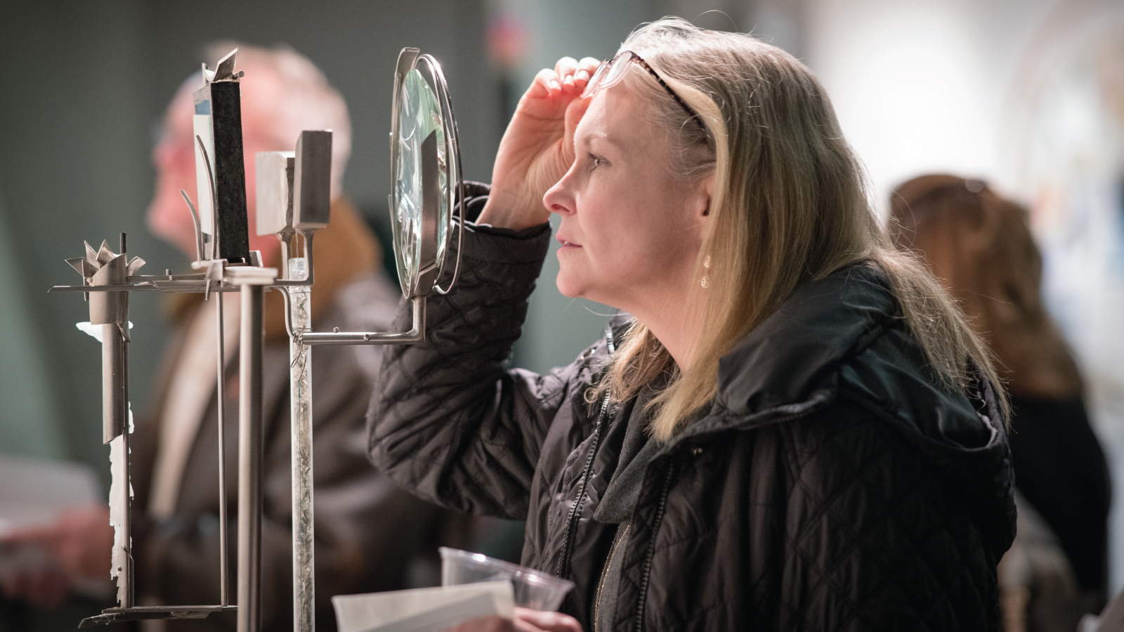 Photo of at Jenkins’ show, a visitor peers through the magnifying glass