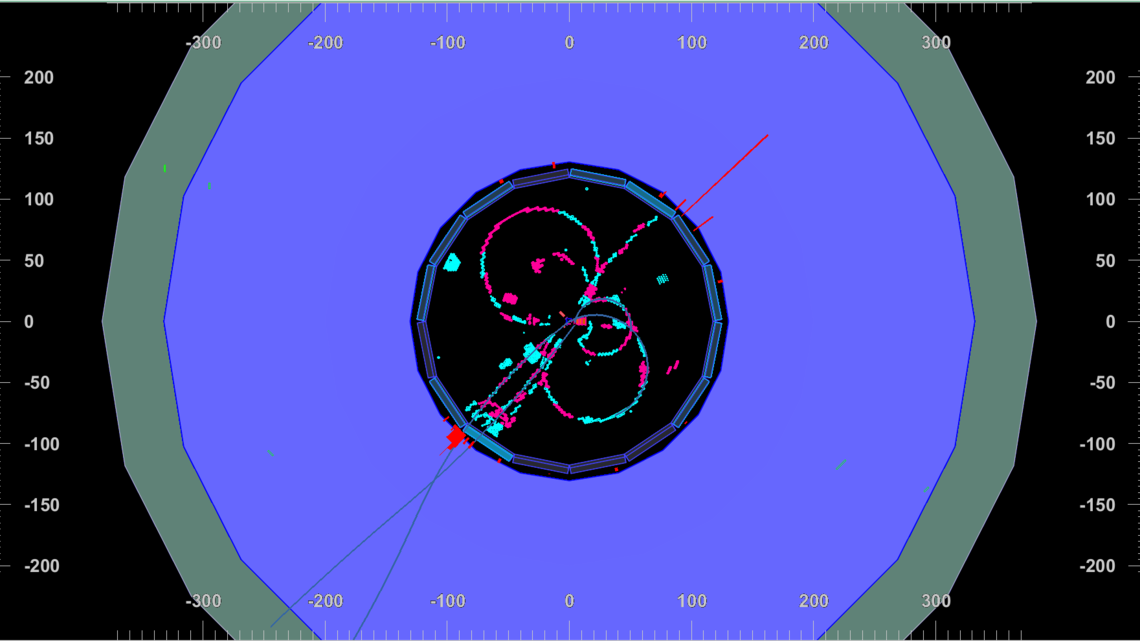 Pink and blue swirls radiate out from a black center: the first particle collisions seen by the Belle II detector.