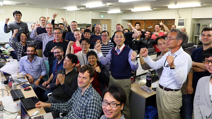 Dozens of researchers celebrate in the control room after first collisions.